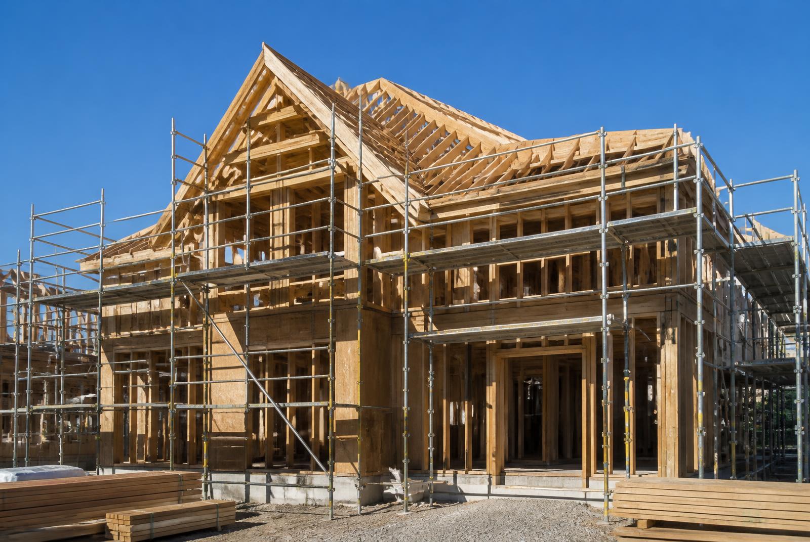 Residential home under construction with framing and roof structure in place